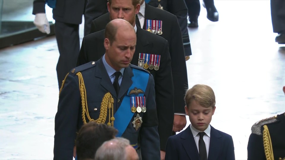 George bowed his head as he walked next to his father