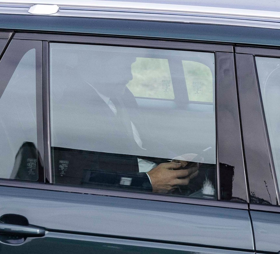 Prince Harry was seen on his phone as he was driven to the airport