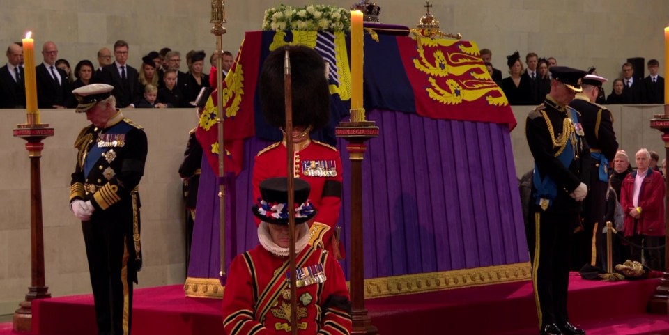 The Queen's children then lowered their heads as they took their places to guard her coffin