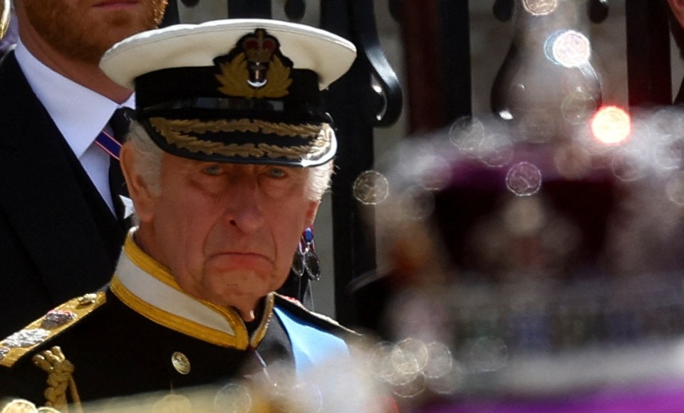 An emotional-looking King views his mother's coffin