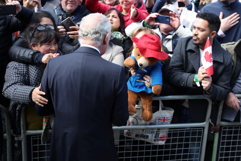 One woman holds up a Paddington Bear toy