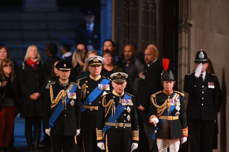 The King led his three siblings to their mother's coffin, as they walked in step to their positions