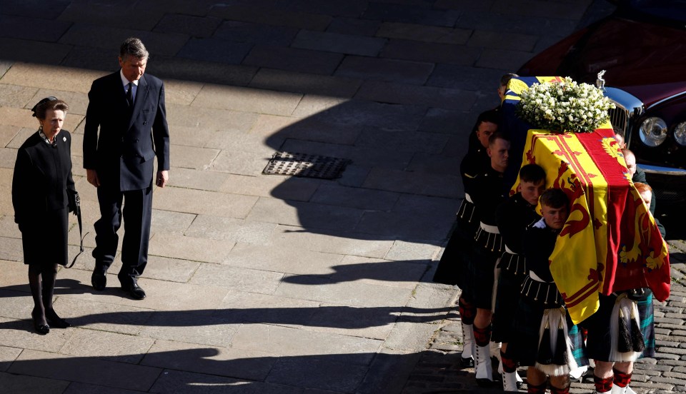 Princess Anne, Princess Royal and husband Vice Admiral Timothy Laurence watch the Queen's coffin be carried to a hearse to go to to Edinburgh airport