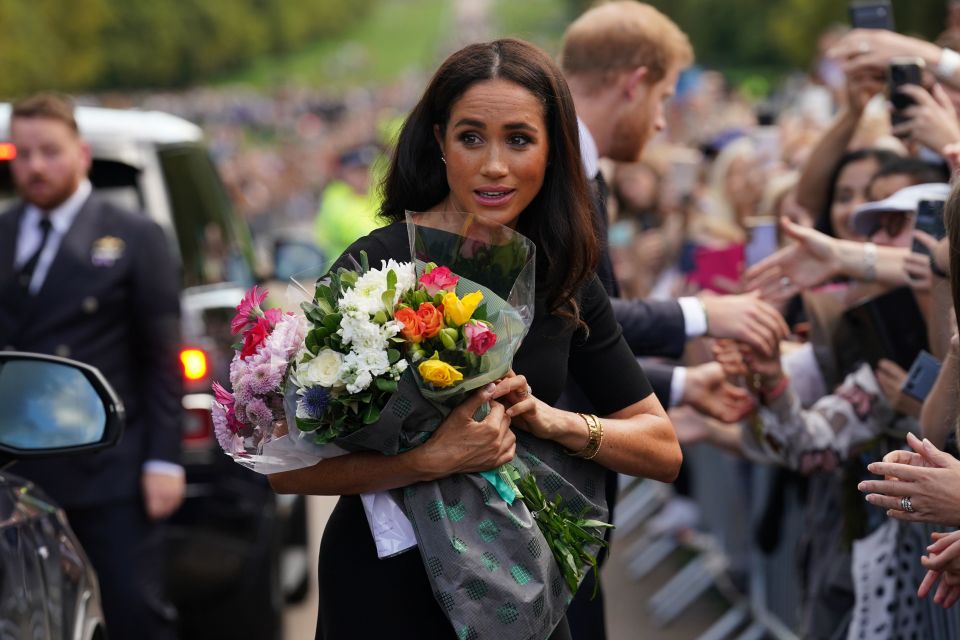 Meghan Markle was given bunches of flowers as she did the rounds on a walk-about at Windsor