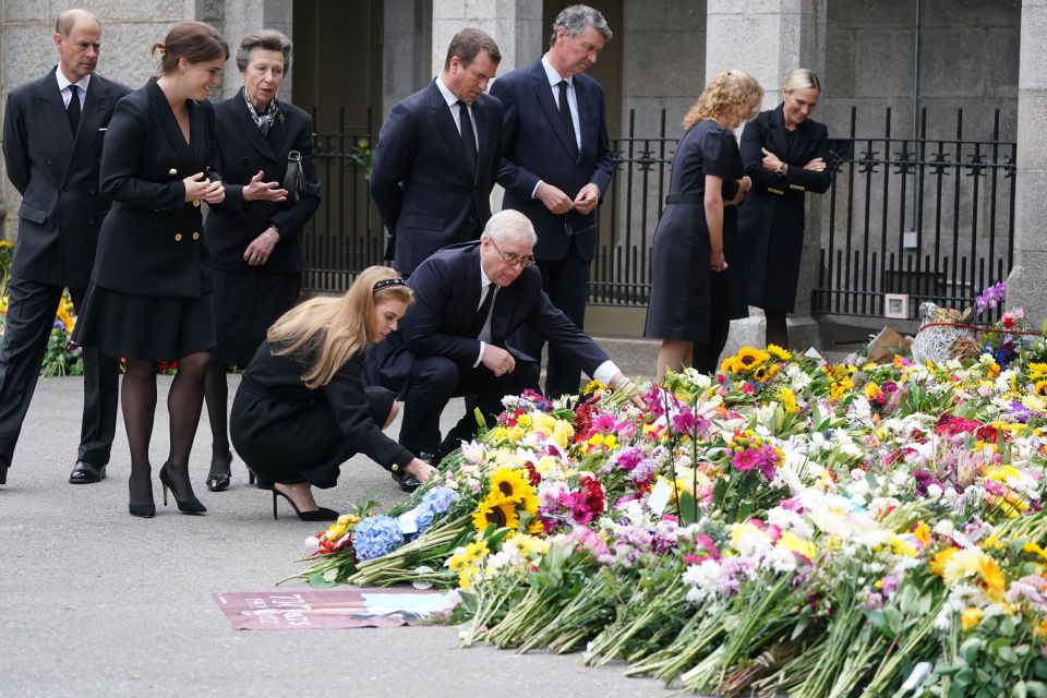 Members of the royal family paused to observe flowers and tributes left at the gates of Balmoral