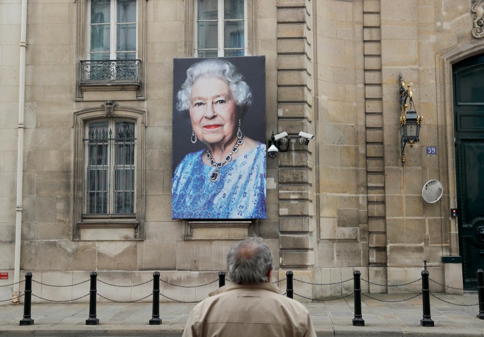 A huge portrait of Her Majesty has been hung outside the British Embassy in Paris