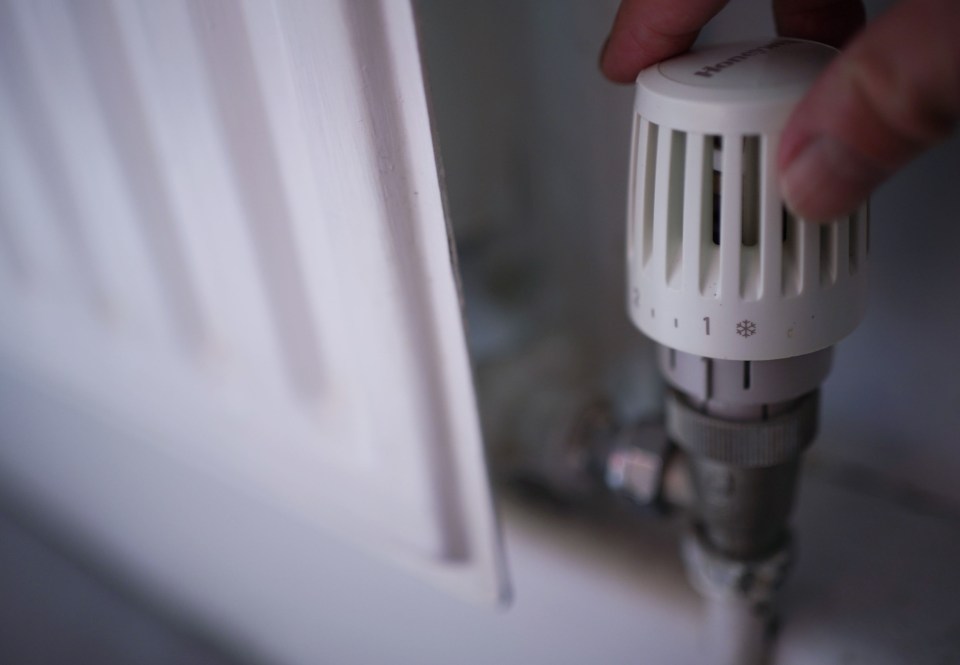 a person is adjusting a honeywell thermostat on a radiator