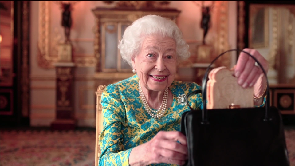 A beaming Queen showed the beloved bear she had her own hiding spot for his favourite treat in her iconic handbag