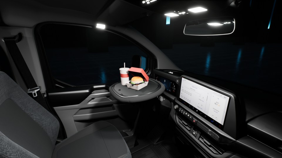 The new Ford E-Transit Custom's steering wheel folds upwards to create a flat surface for using laptops or eating lunch