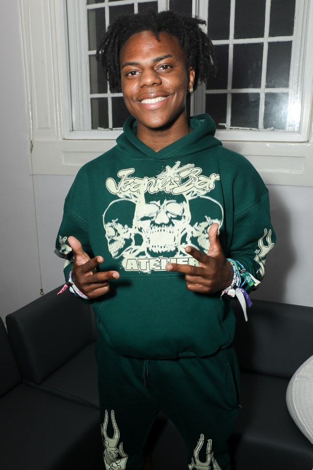 a young man wearing a green hoodie with a skull on it