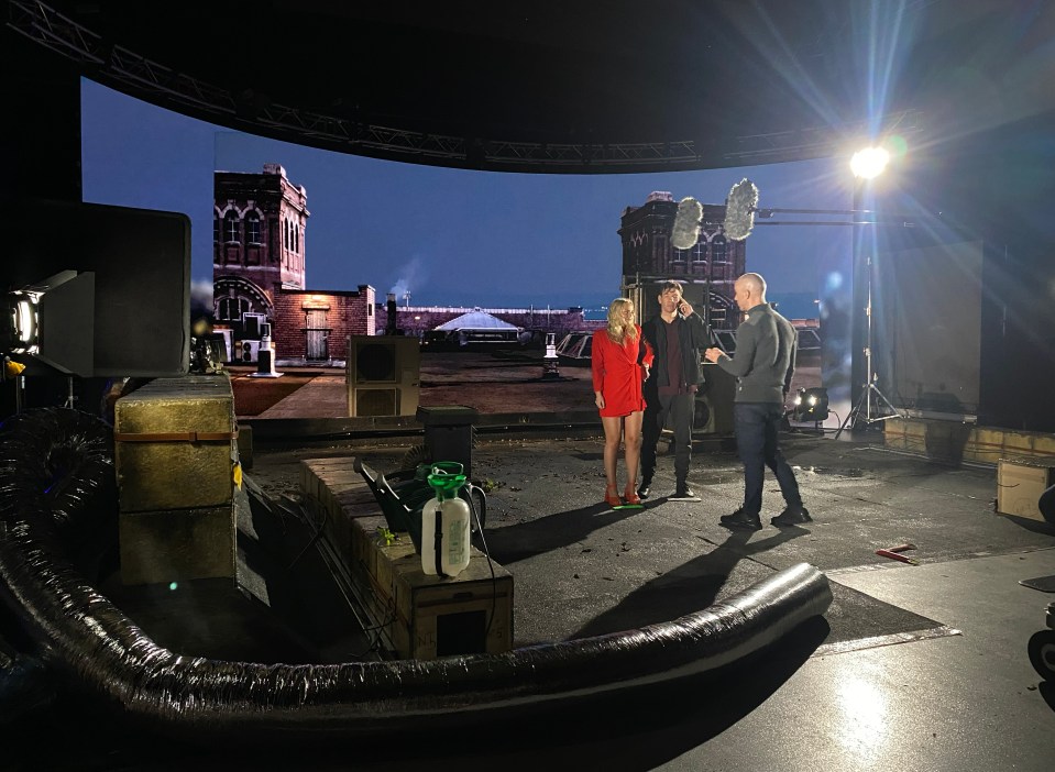 The pair appear to be grappling outside at night with the Manchester skyline behind them