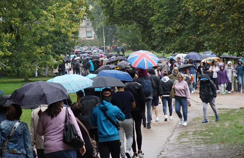 Members of the public queue to lay flowers for the Queen at the gates of Buckingham Palace