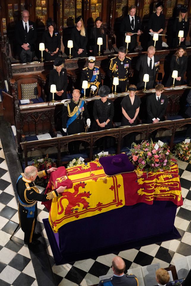 The King places the Queen’s Company Camp Colour of the Grenadier Guards on the coffin