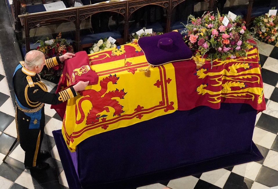 King Charles places the Queen's Company Camp Colour of the Grenadier Guards on her coffin