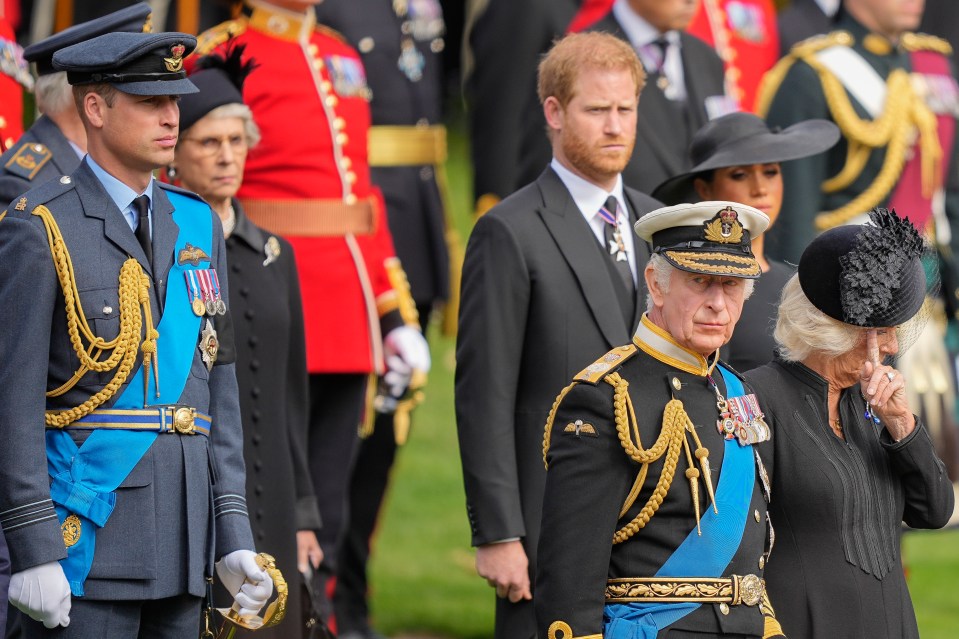 King Charles, pictured with his wife, the Queen Consort, and two sons William and Harry as they watch Her Majesty's coffin go by