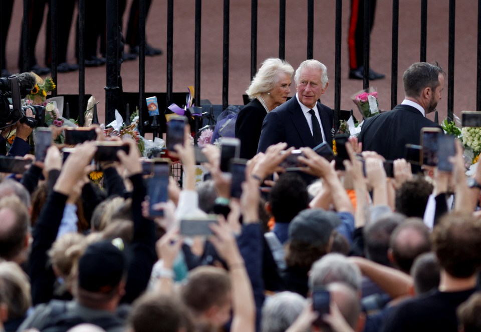 King Charles and Queen Camilla are cheered by the crowd outside Buckingham Palace