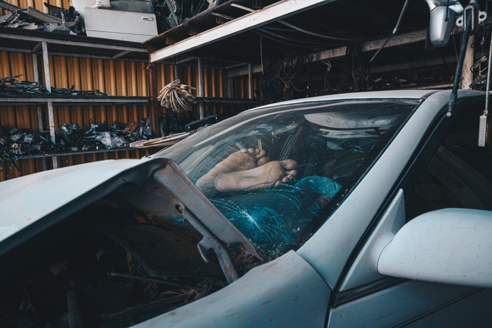 A worker puts their feet up and takes a rest in one of the crumbling motors