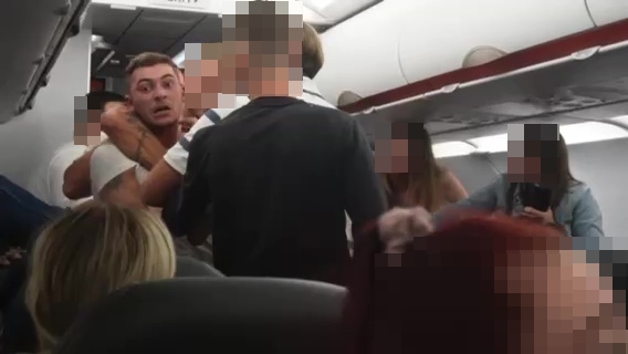 A group of passengers is trying to restrain him