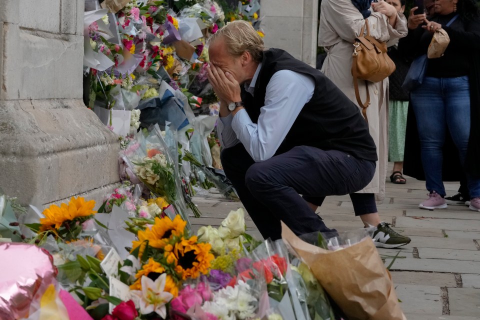 A mourner is overcome with emotion as he pays his respects