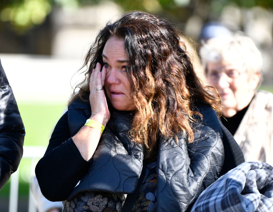 A woman shows her emotion as she leaves the Palace of Westminster after paying her respects to the Queen