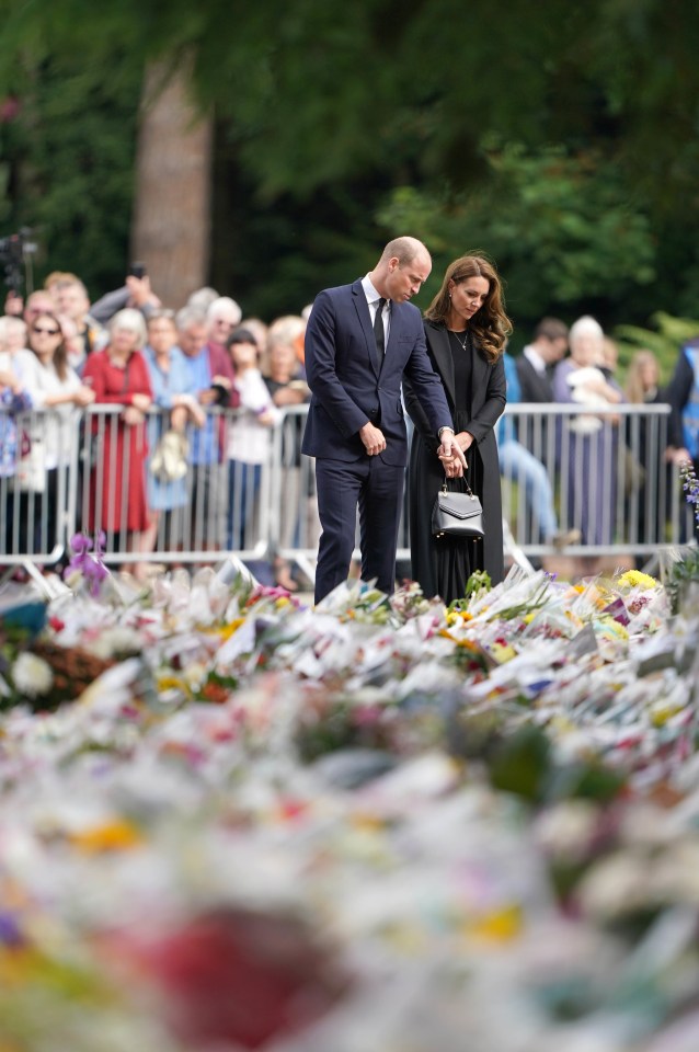 Crowds watch William and Kate look at flowers at Sandringham