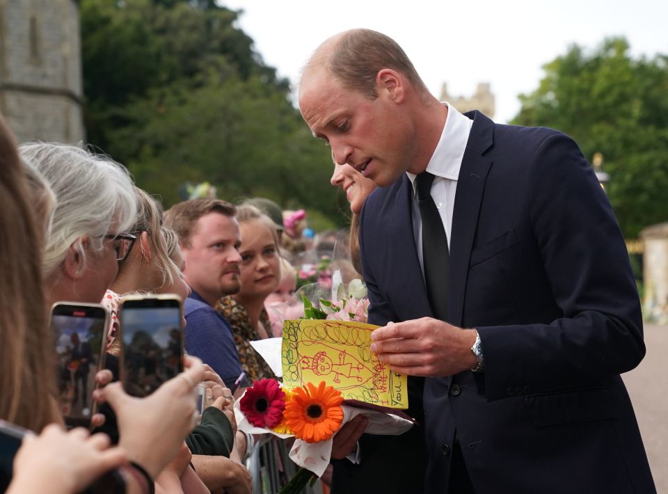 Prince William is handed flowers and a card written by a youngster as he thanks the public for their touching tributes to his late grandmother