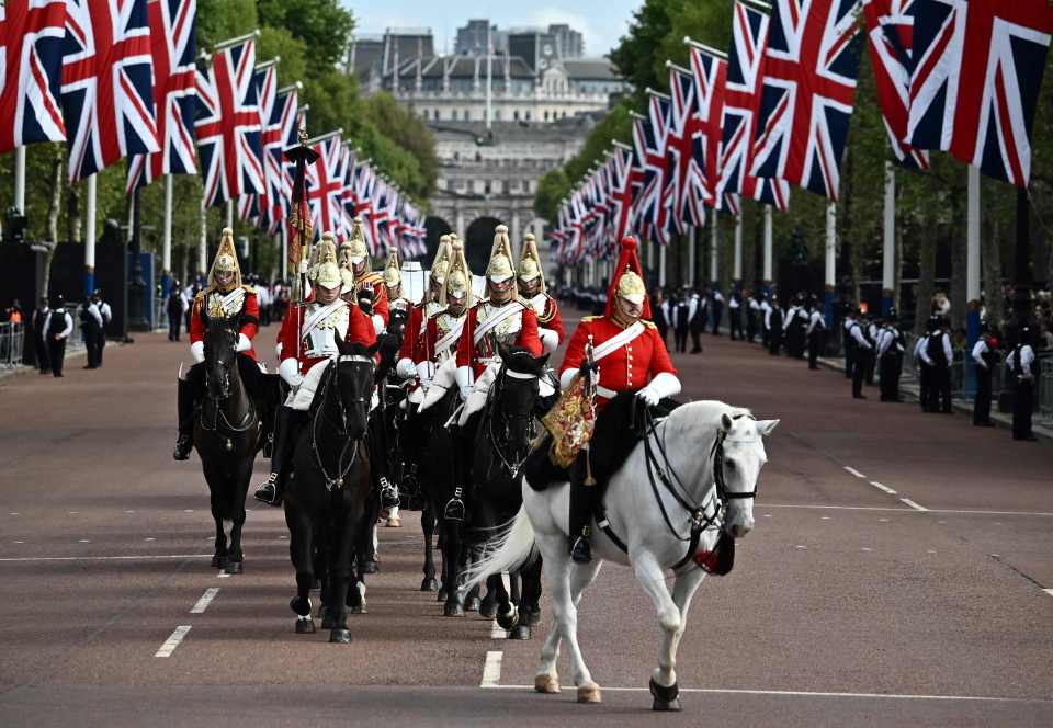 Members of the Life Guards, a unit of the Household Cavalry, ride along The Mall ahead of the ceremonial procession