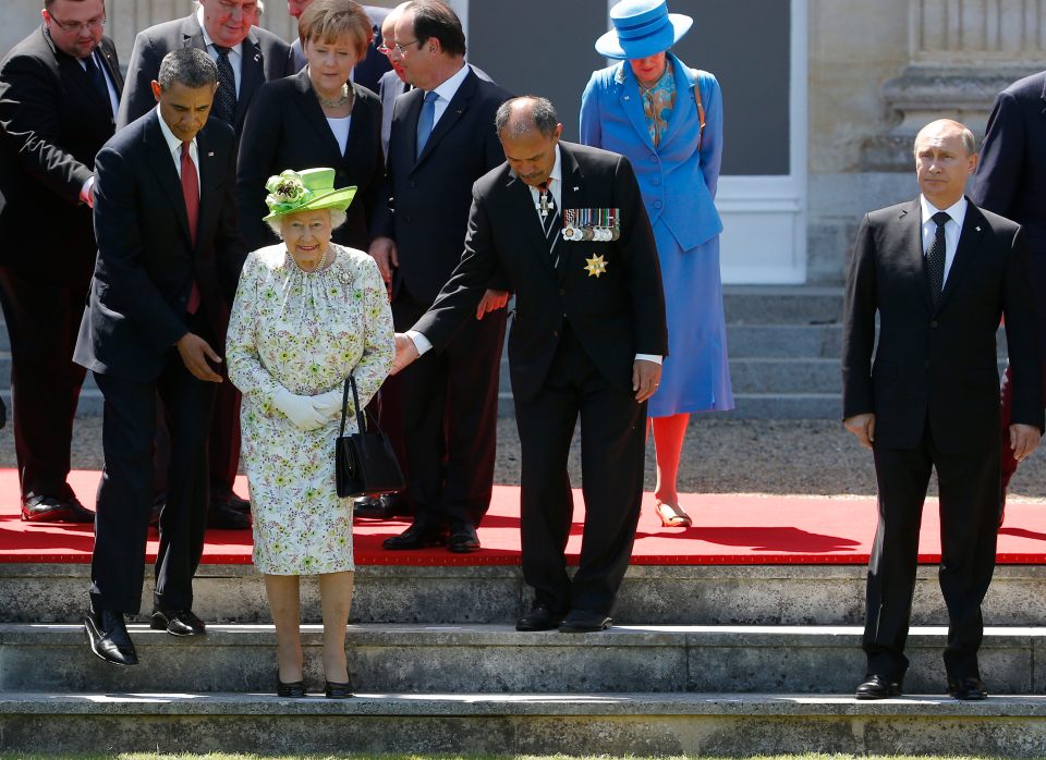 Putin stood to one side as other leaders helped the Queen in 2014