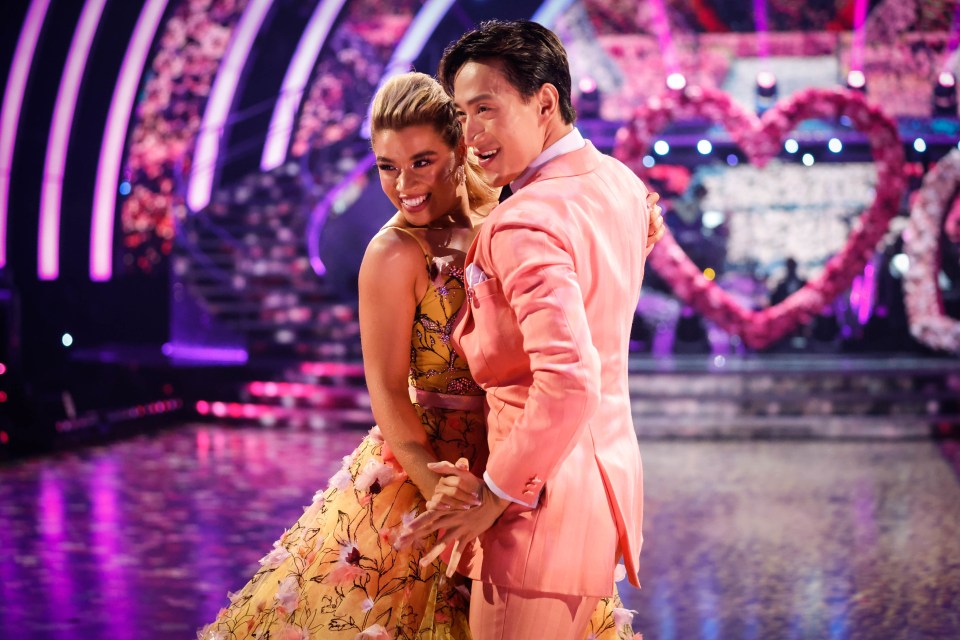 a man in a pink suit is dancing with a woman in a yellow dress