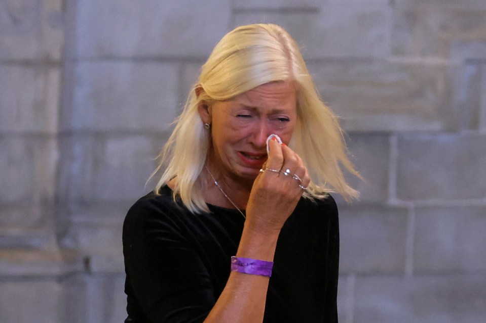 A woman reacts as she pays her respects inside Westminster Hall