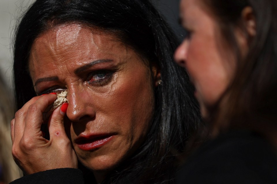 A woman dabs away a tear as she leaves Westminster Hall