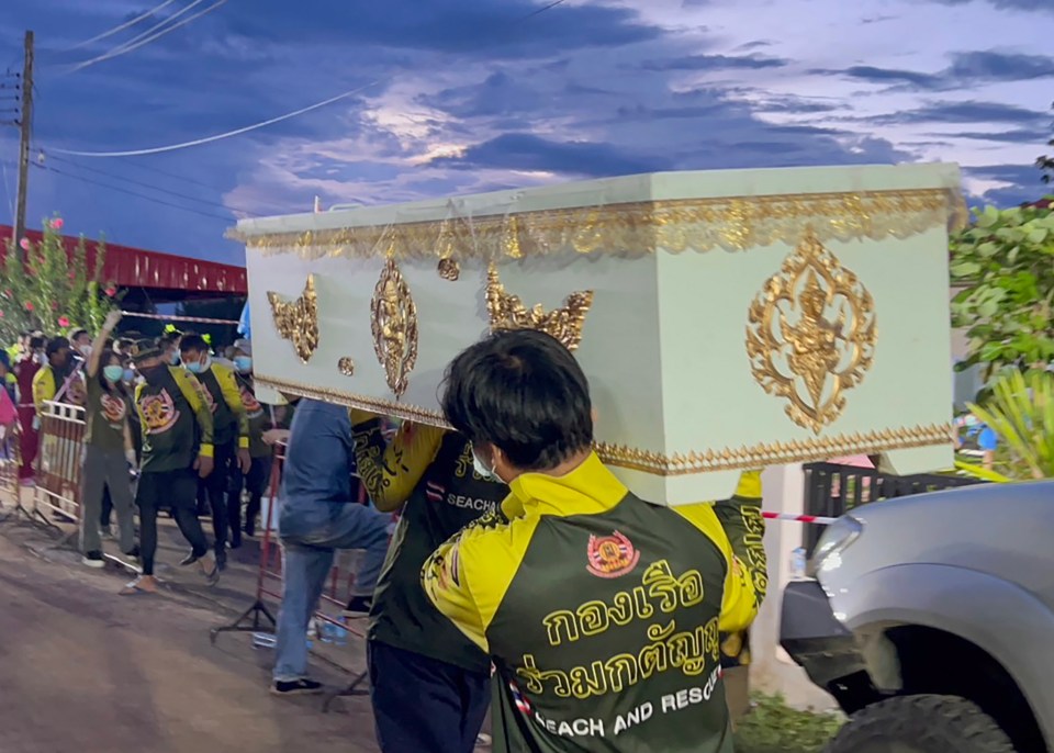 Rescue workers carrying tiny coffins following the massacre