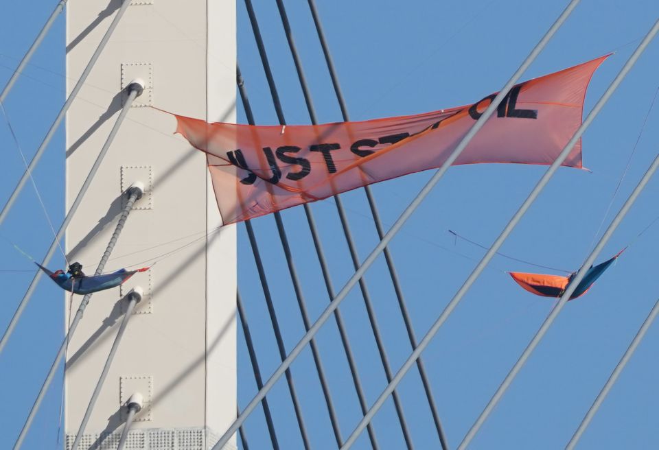 Eco warriors lying in hammocks on the QEII Bridge, which links Kent and Essex