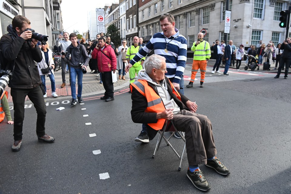 A furious taxi driver attempted to drag a protestor out of the street as he shouted 'people have to get to hospital