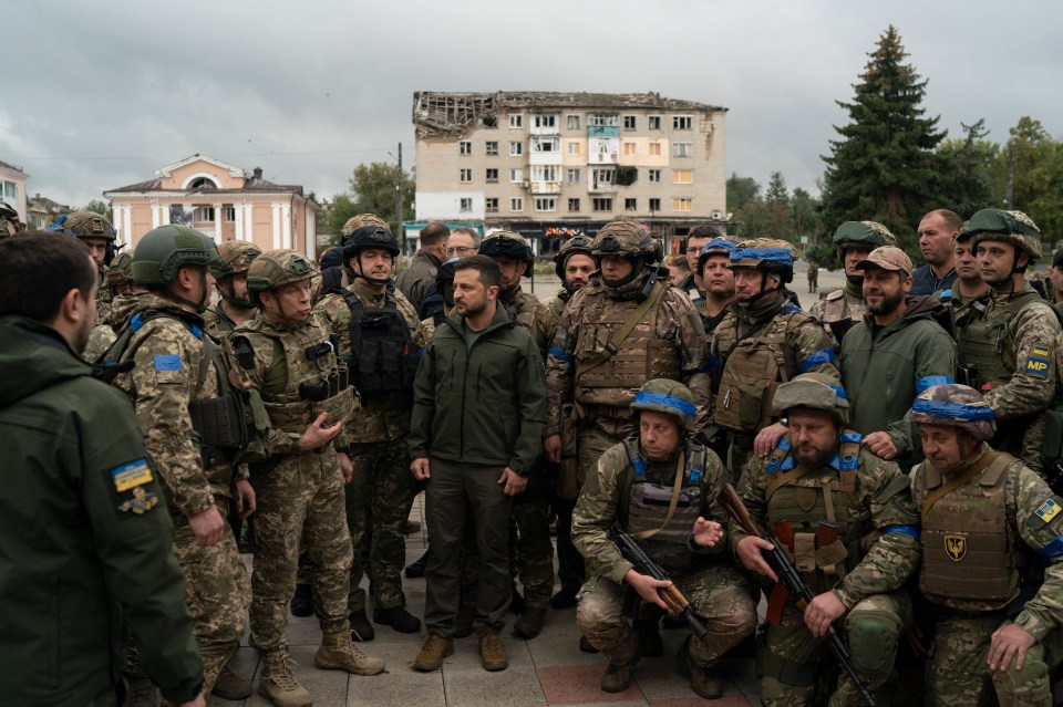 Volodymyr Zelensky stands with soldiers after attending a flag-raising ceremony in the freed Izyum