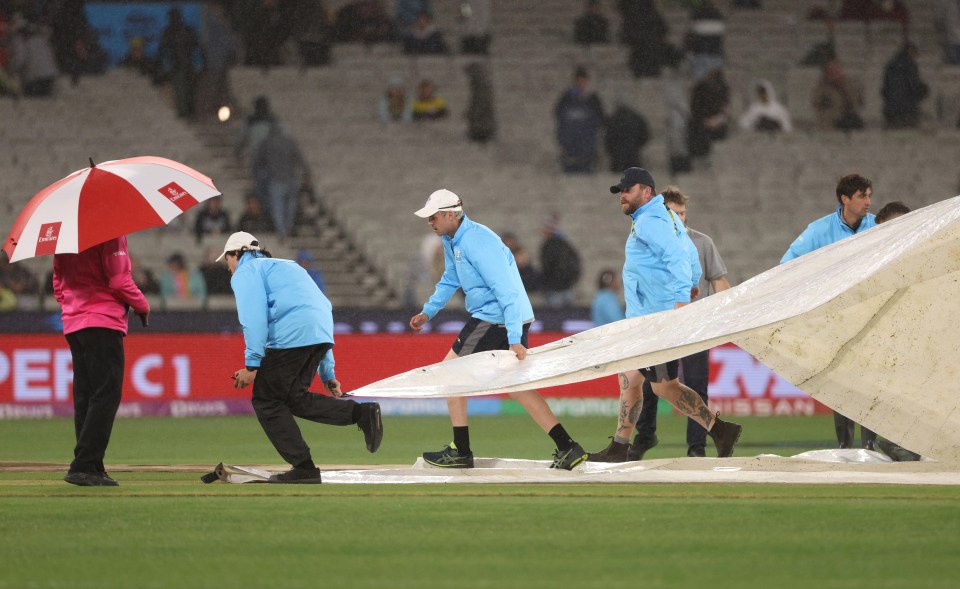 Ground staff cover the pitch as rain delays the start of play Australia v England before being washed off