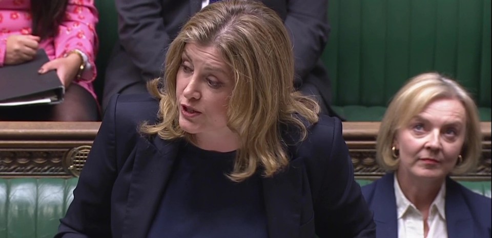 Penny Mordaunt speaking with Truss sneaking in and sitting behind her