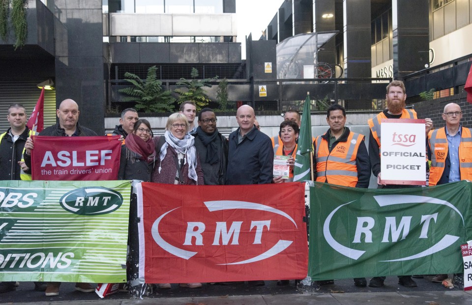 RMT boss Mick Lynch, centre, joins strikers on the picket line in London