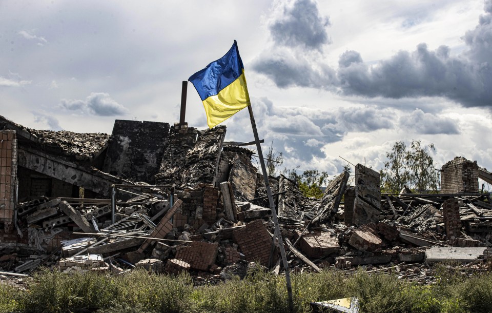 Ukrainian flag waves in a residential area heavily damaged in the village of Dolyna in Donetsk Oblast