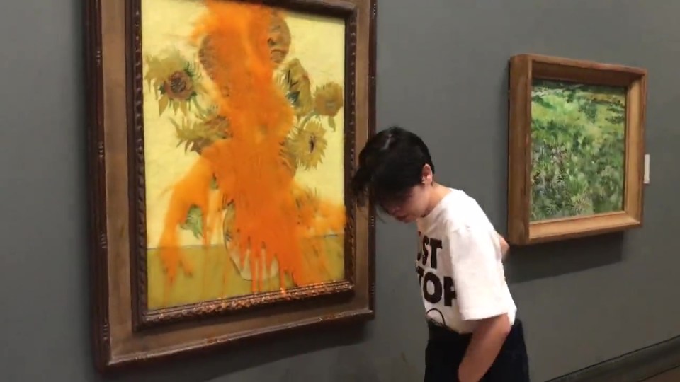 a person wearing a shirt that says " best of " looks at a painting