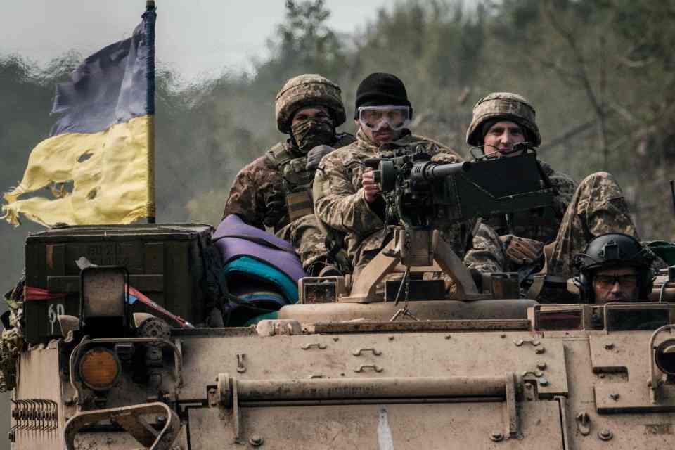 Ukrainian soldiers ride near the recently retaken town of Lyman in Donetsk region