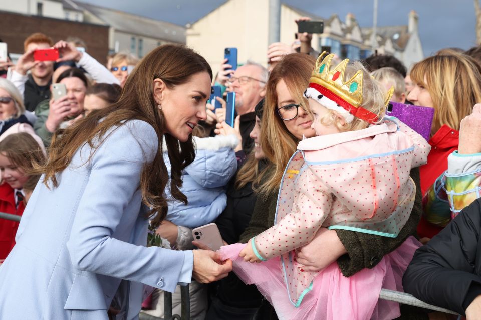 Kate meets a mum with her tot, who donned a crown and sported a spotty jacket