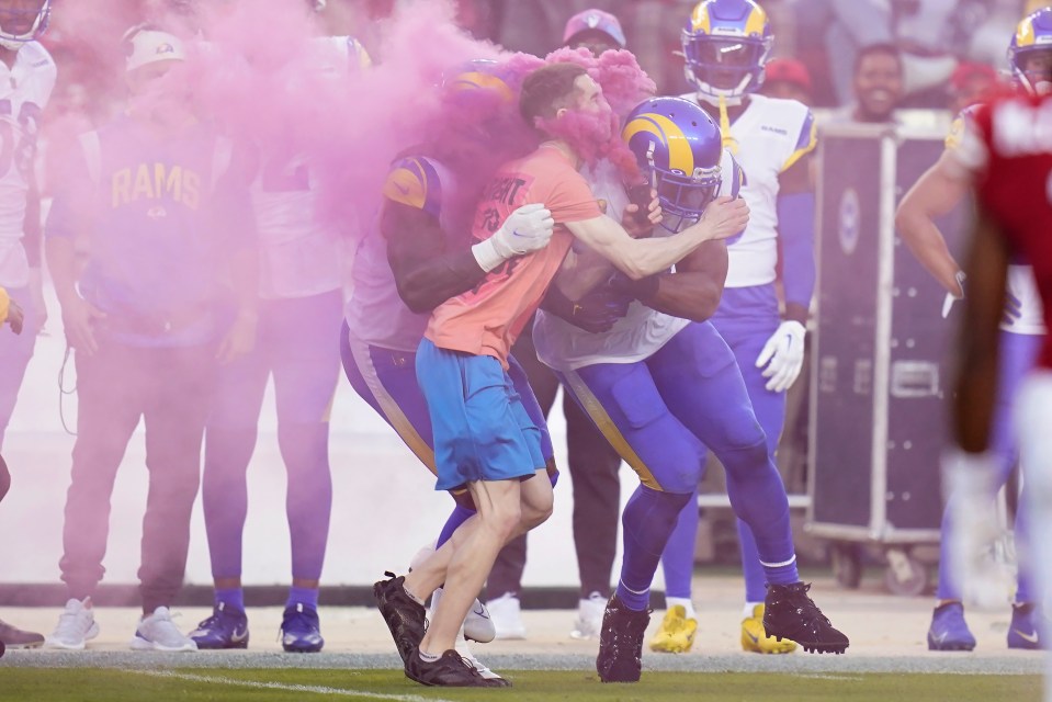 Bobby Wagner and Takk McKinley wipe out a streaker