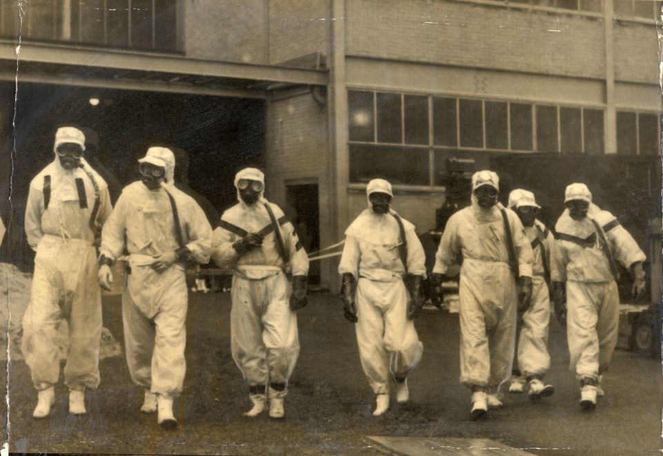 Staff in protective suits start the clean up after the disaster