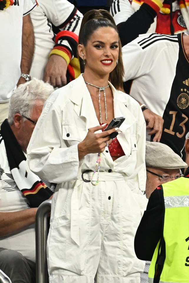 She attended the match in a white outfit with a sparkly red piece underneath