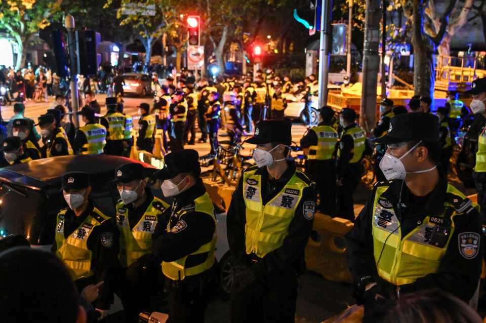 Officers block Wulumuqi street, named for Urumqi in Mandarin, in Shanghai