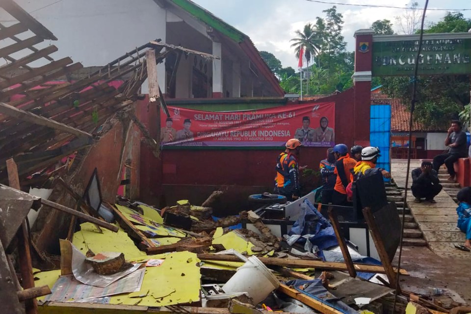 Rescuers inspect a school damaged by the 5.6 magnitude earthquake