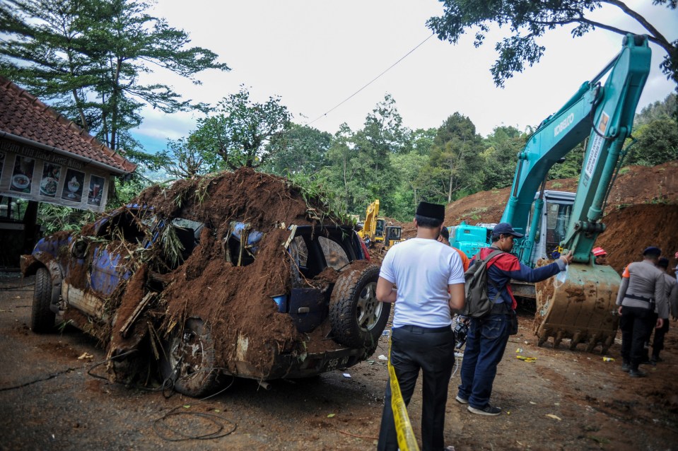 A damaged car at the site of a landslide following the quake