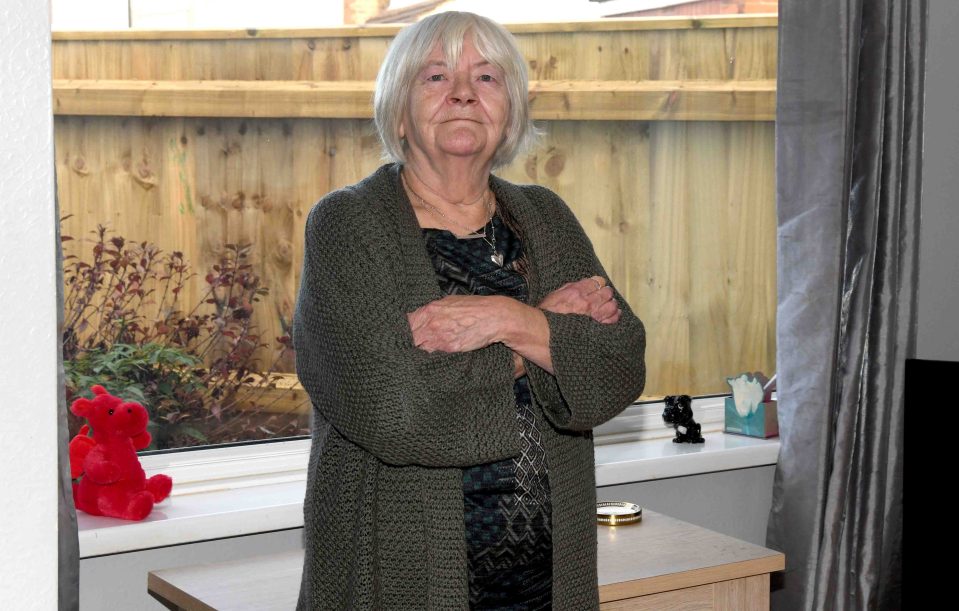 Sheila Parkinson with the 6ft fence outside her home in Grimsby