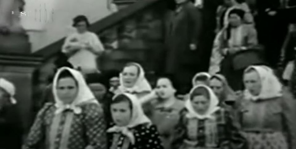 One woman stands out in news reel footage of a crowd leaving a building